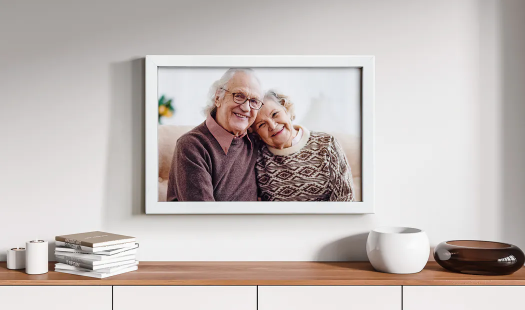 Een ingelijste foto van opa en oma op een dressoir