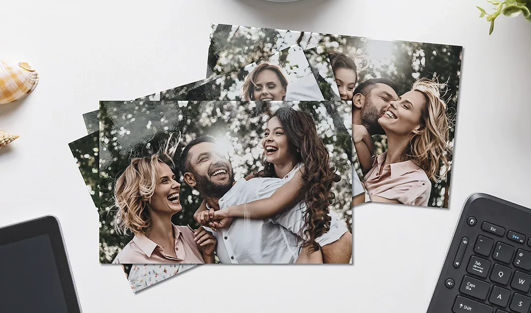 Handen die een fotoafdruk vasthouden van drie kinderen op vakantie